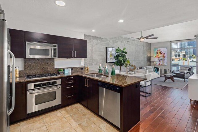 800 The Mark Ln Unit 602, San Diego, CA 92101 - kitchen featuring stainless steel appliances, a ceiling fan, dark stone countertops, open floor plan, and dark brown cabinets