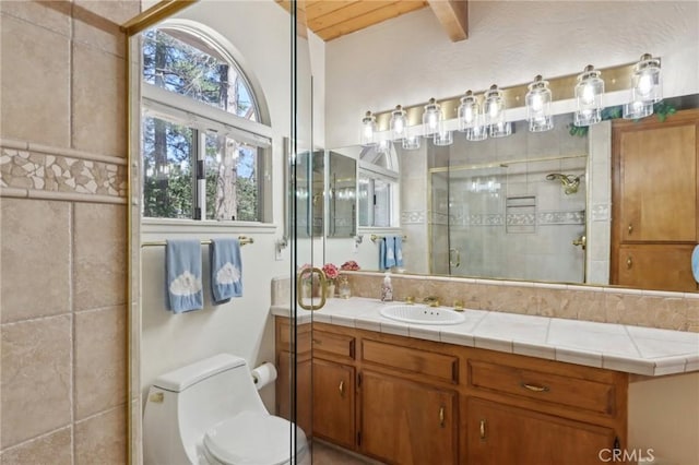 24571 Albrun Dr, Crestline, CA 92325 - bathroom with vanity, a stall shower, toilet, and beam ceiling