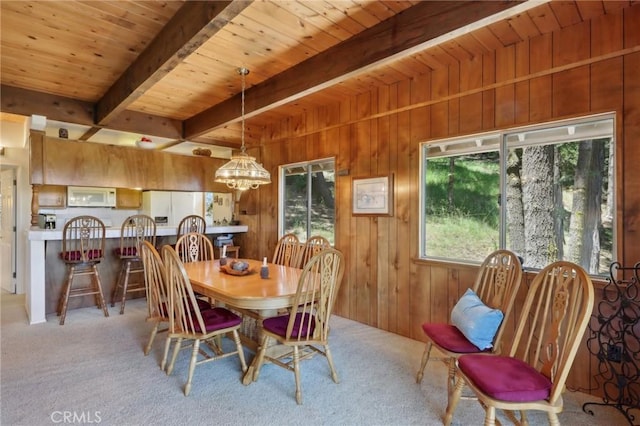 24571 Albrun Dr, Crestline, CA 92325 - dining space featuring a chandelier, wood ceiling with exposed beams, wood walls, and carpet