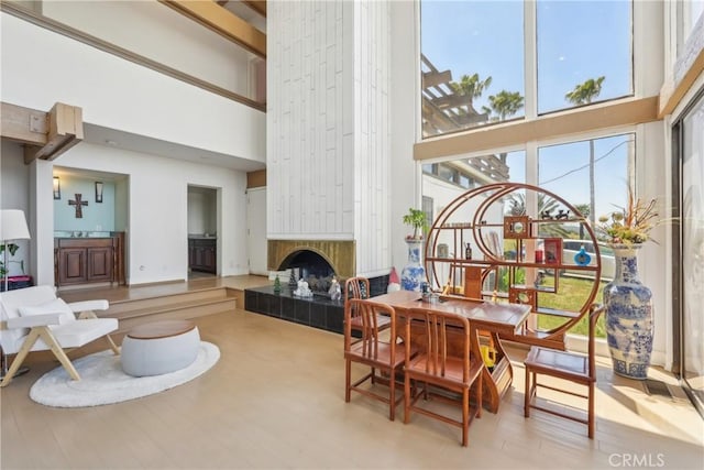 22702 Timbertop Ln, Diamond Bar, CA 91765 - dining room featuring a towering ceiling, plenty of natural light, a tile fireplace, and wood finished floors