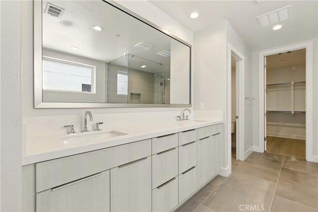 208 Stage, Irvine, CA 92618 - bathroom featuring a stall shower, double vanity, a walk in closet, tile patterned floors, and recessed lighting