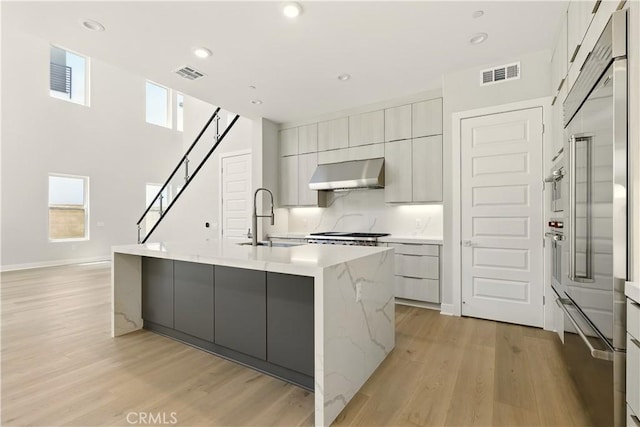 208 Stage, Irvine, CA 92618 - kitchen featuring extractor fan, modern cabinets, light wood-style flooring, built in refrigerator, and recessed lighting