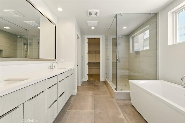 208 Stage, Irvine, CA 92618 - full bath with a shower stall, a freestanding tub, double vanity, a walk in closet, and recessed lighting