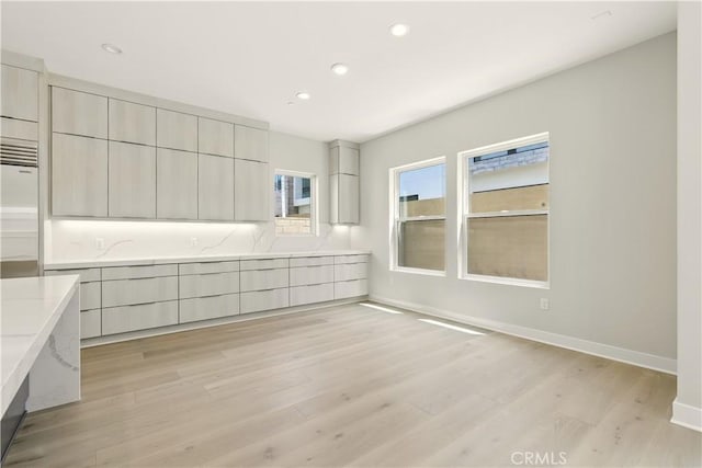 208 Stage, Irvine, CA 92618 - kitchen with modern cabinets, light wood-style floors, recessed lighting, light stone counters, and stainless steel built in fridge