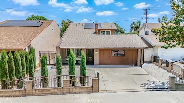 view of front of home with a fenced front yard, roof with shingles, solar panels, driveway, and a gate
