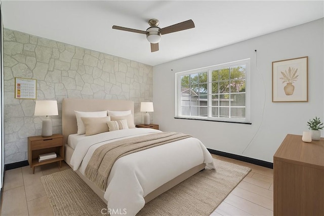 bedroom with an accent wall and ceiling fan