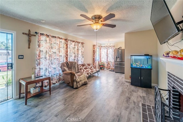 1763 W 245th St, Torrance, CA 90501 - living area with ceiling fan, a tiled fireplace, plenty of natural light, light wood-style flooring, and a textured ceiling