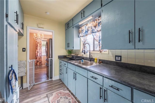1763 W 245th St, Torrance, CA 90501 - kitchen with a sink, dark countertops, light wood-type flooring, a chandelier, and baseboards