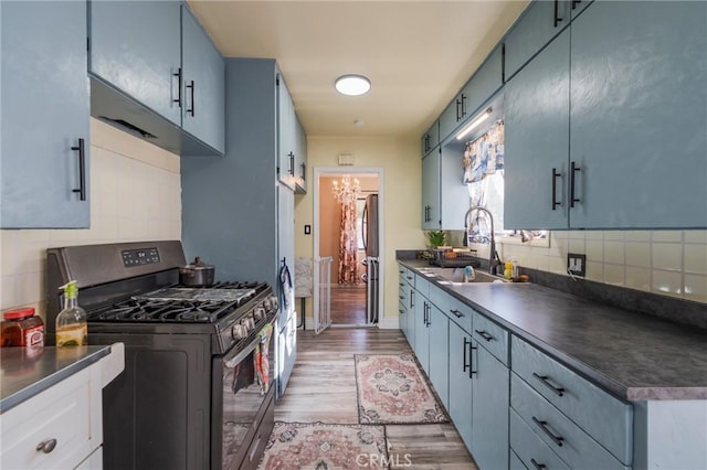 1763 W 245th St, Torrance, CA 90501 - kitchen with appliances with stainless steel finishes, dark countertops, a sink, light wood-style flooring, and tasteful backsplash