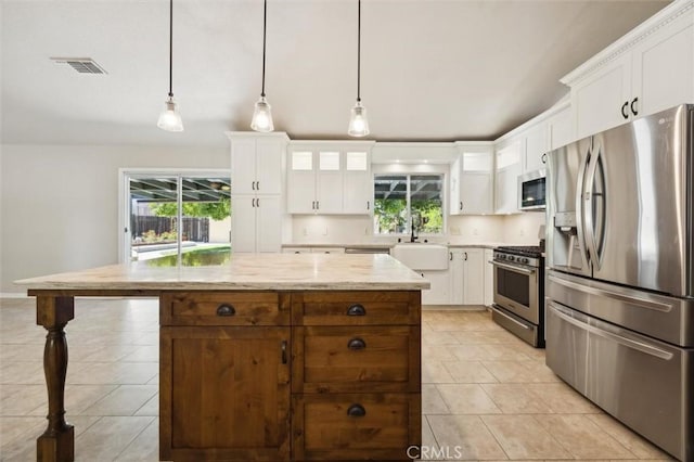 8825 Old Santa Rosa Rd, Atascadero, CA 93422 - kitchen featuring stainless steel appliances, light tile patterned floors, healthy amount of natural light, and white cabinets