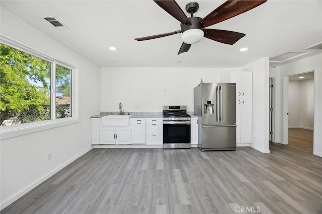8825 Old Santa Rosa Rd, Atascadero, CA 93422 - kitchen with stainless steel appliances, light countertops, light wood-style floors, white cabinets, and recessed lighting