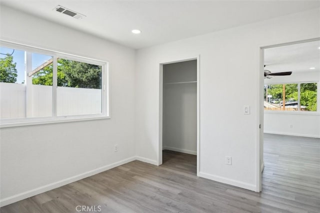 8825 Old Santa Rosa Rd, Atascadero, CA 93422 - unfurnished bedroom with multiple windows, wood finished floors, a walk in closet, recessed lighting, and a closet