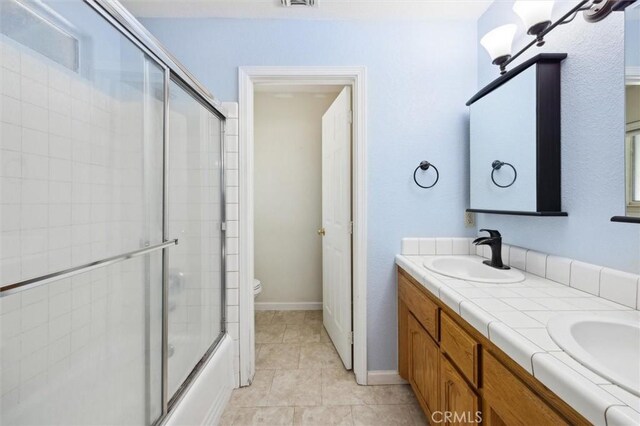 8825 Old Santa Rosa Rd, Atascadero, CA 93422 - bathroom featuring double vanity, toilet, shower / bath combination with glass door, and tile patterned floors