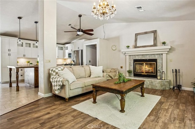 8825 Old Santa Rosa Rd, Atascadero, CA 93422 - living area with vaulted ceiling, ceiling fan, a tiled fireplace, dark wood-type flooring, and a chandelier