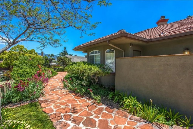 34879 Olive Tree Ln, Yucaipa, CA 92399 - view of home's exterior featuring stucco siding, a tiled roof, and a chimney