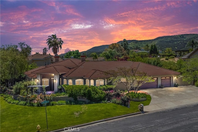 34879 Olive Tree Ln, Yucaipa, CA 92399 - view of front of house with a tile roof, a chimney, concrete driveway, a yard, and an attached garage
