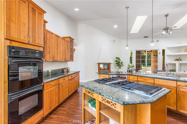 34879 Olive Tree Ln, Yucaipa, CA 92399 - kitchen featuring a sink, a skylight, a center island, stainless steel gas stovetop, and dark wood-style flooring