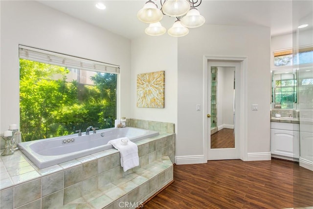 34879 Olive Tree Ln, Yucaipa, CA 92399 - bathroom with vanity, a bath, a chandelier, wood finished floors, and baseboards