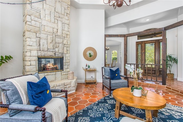 34879 Olive Tree Ln, Yucaipa, CA 92399 - tiled living area with arched walkways, a chandelier, baseboards, and a stone fireplace