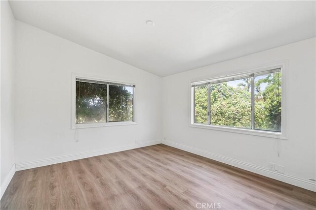 7008 Hawarden Dr, Riverside, CA 92506 - unfurnished room with vaulted ceiling, light wood-style floors, and baseboards