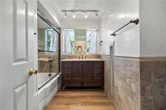 7008 Hawarden Dr, Riverside, CA 92506 - full bathroom featuring tile walls, shower / tub combination, a wainscoted wall, vanity, and wood finished floors