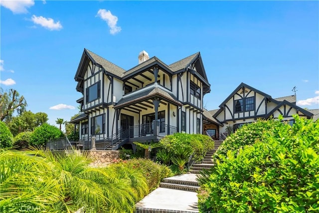 7008 Hawarden Dr, Riverside, CA 92506 - tudor house with stairs, stucco siding, a chimney, and a shingled roof