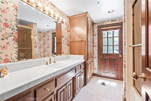 7008 Hawarden Dr, Riverside, CA 92506 - bathroom with wallpapered walls, tile patterned floors, a shower with shower door, and vanity
