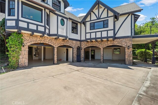 7008 Hawarden Dr, Riverside, CA 92506 - view of front of home with stone siding, driveway, stucco siding, and a shingled roof