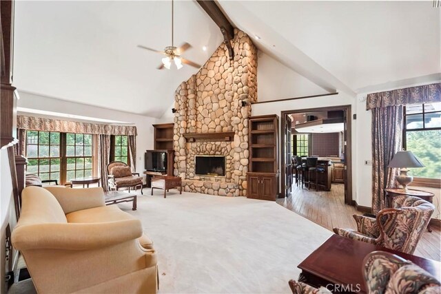7008 Hawarden Dr, Riverside, CA 92506 - living room featuring healthy amount of natural light, high vaulted ceiling, a stone fireplace, beam ceiling, and a ceiling fan