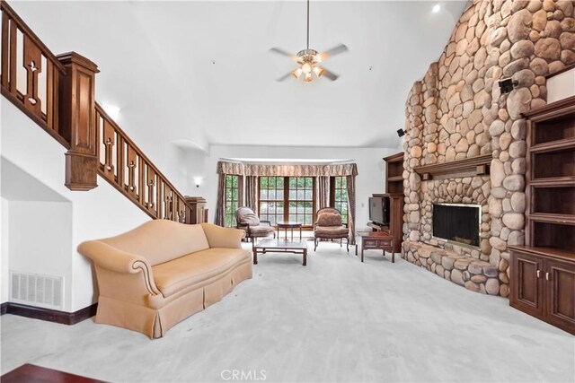 7008 Hawarden Dr, Riverside, CA 92506 - living room featuring carpet, stairs, a ceiling fan, a fireplace, and high vaulted ceiling