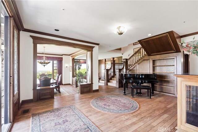 7008 Hawarden Dr, Riverside, CA 92506 - entrance foyer featuring ornamental molding, wood finished floors, stairway, baseboards, and a chandelier