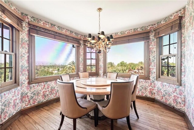 7008 Hawarden Dr, Riverside, CA 92506 - dining room with wallpapered walls, a chandelier, baseboards, and hardwood / wood-style flooring