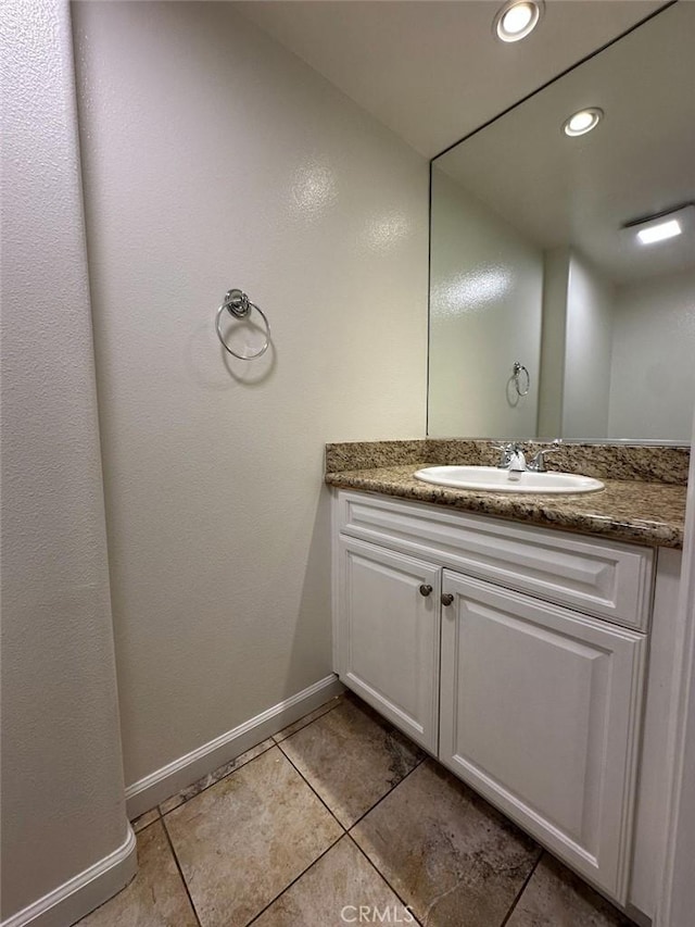 bathroom featuring vanity, baseboards, tile patterned flooring, and recessed lighting
