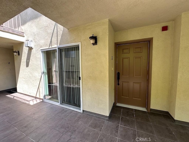 entrance to property featuring stucco siding