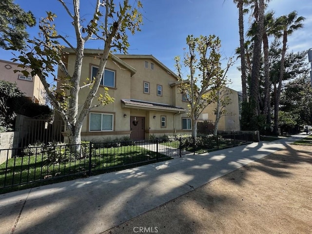 view of front of home with stucco siding and a fenced front yard