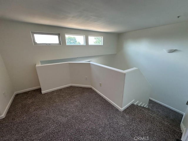 carpeted empty room featuring baseboards