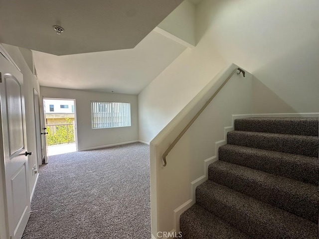 staircase featuring carpet floors and baseboards