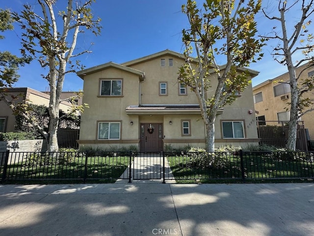 view of front of house with stucco siding and a fenced front yard