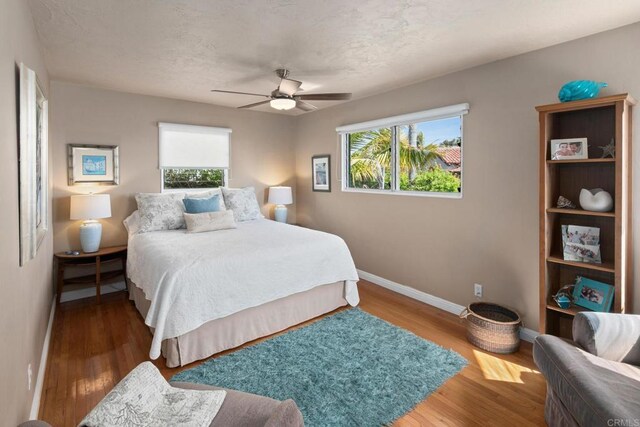 1855 Rubenstein Dr, Cardiff By The Sea, CA 92007 - bedroom with baseboards, multiple windows, wood finished floors, and ceiling fan