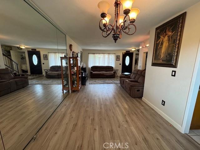 13278 Parkland Cir, Sylmar, CA 91342 - living area with a chandelier, light wood-style floors, and baseboards