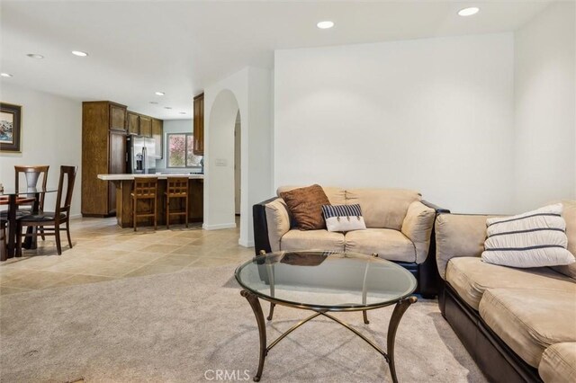 1334 Tourney Hill Ln Unit 61, Nipomo, CA 93444 - living area with arched walkways, recessed lighting, baseboards, light tile patterned flooring, and light colored carpet