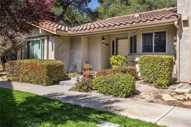 1334 Tourney Hill Ln Unit 61, Nipomo, CA 93444 - view of exterior entry with stucco siding and a tile roof