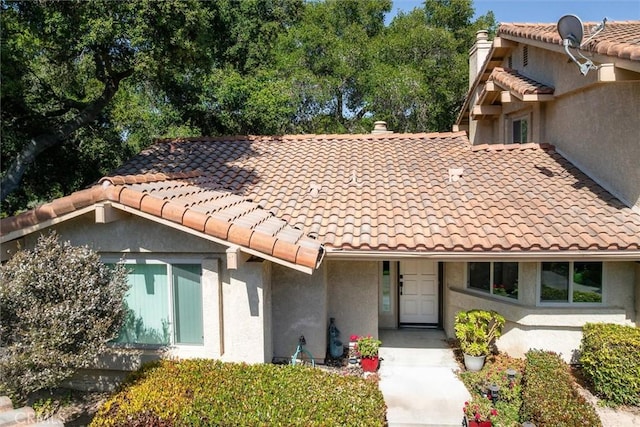 1334 Tourney Hill Ln Unit 61, Nipomo, CA 93444 - view of front of house featuring stucco siding, a chimney, and a tiled roof