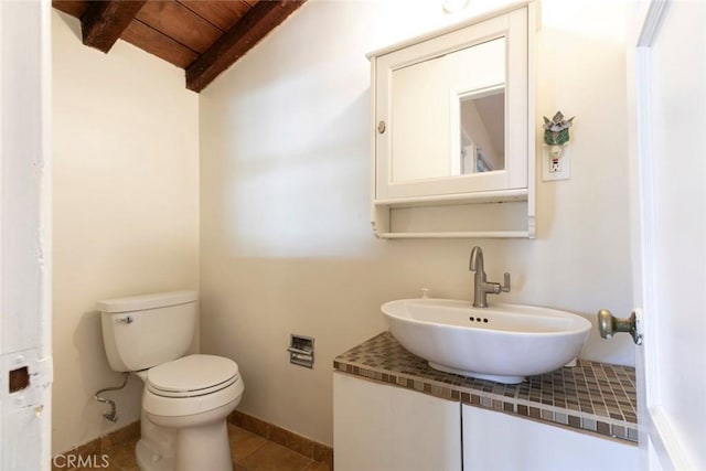 14719 Wyandotte St, Van Nuys, CA 91405 - bathroom featuring wooden ceiling with exposed beams, toilet, baseboards, vanity, and tile patterned flooring