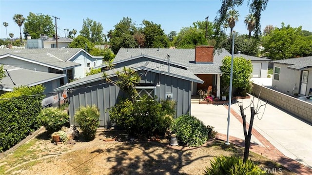 14719 Wyandotte St, Van Nuys, CA 91405 - back of property featuring board and batten siding, a shingled roof, and a chimney