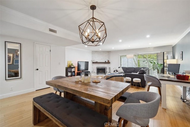 4455 Fulton Ave Unit 2, Sherman Oaks, CA 91423 - dining area featuring a fireplace, a chandelier, light wood-type flooring, crown molding, and recessed lighting