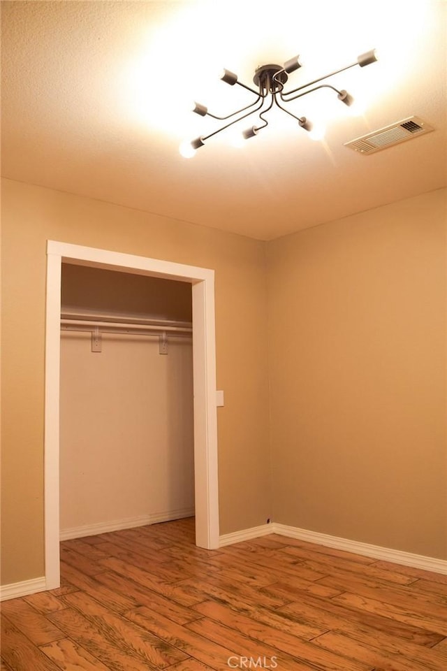 5 W 12th St, Paso Robles, CA 93446 - unfurnished bedroom with a chandelier, wood finished floors, a closet, and baseboards
