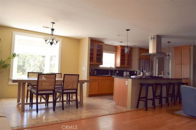 5 W 12th St, Paso Robles, CA 93446 - kitchen with island exhaust hood, freestanding refrigerator, a sink, dark countertops, and a breakfast bar area