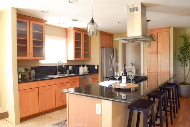 5 W 12th St, Paso Robles, CA 93446 - kitchen with stainless steel appliances, island range hood, a sink, a breakfast bar area, and glass insert cabinets