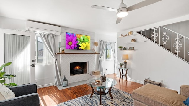 1420 E Ln, Imperial Beach, CA 91932 - living room featuring an AC wall unit, wood finished floors, ceiling fan, a tiled fireplace, and stairway